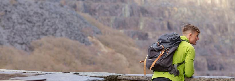 Ymwelydd ar y safle - visitor looks out from castle walls