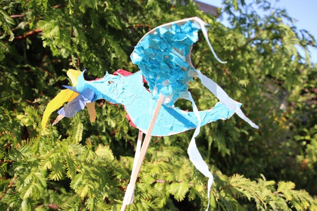 Dragon puppet being worked outside in bright sunshine